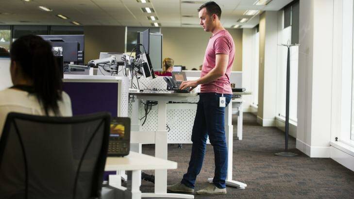 PwC consultant Tom Simmonds using a standup desk. No one now has an individual space that is theirs. Photo: Rohan Thomson