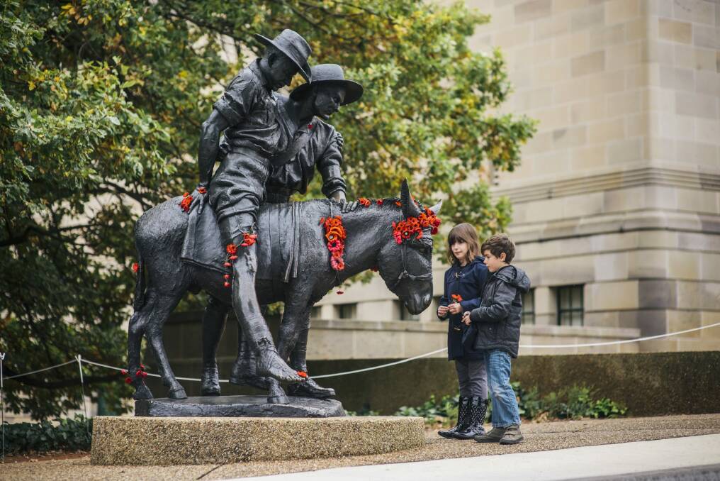 Kate (9) and Ben (7) Redmond, from Brisbane, with the statue of Simpson and his donkey on the 100th anniversary of his death. 

 Photo: Rohan Thomson