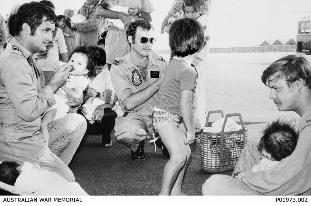 A photograph from the Australian War Memorial archives showing Operation Babylift and   "a case of `all hands to the bottles' during the second RAAF airlift of Vietnamese orphans. Seen here feeding babies at Tan Son Nhut airfield were three crew members from 37 Squadron: (from left) Flight Lieutenant (FLTLT) Ian S. Frame, FLTLT H.F.B. Howell and Flying Officer Ian K. Scott. (Donor I.S. Frame)''. Photo: Australian War Memorial : P01973.002