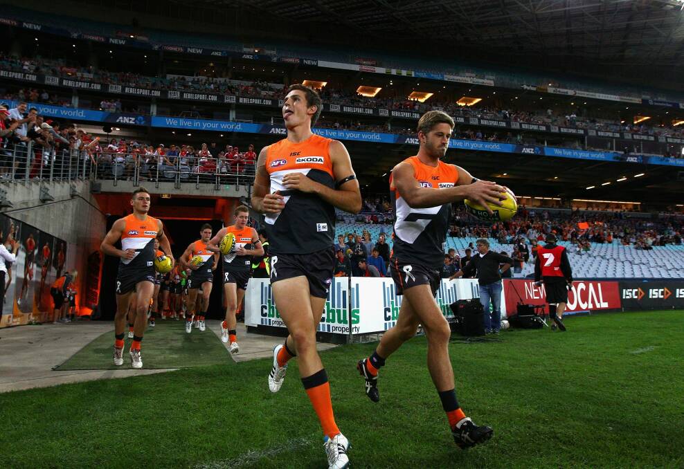 Tough start: Phil Davis and Callan Ward run out onto the field during the round one match between the  Giants and the Swans in 2012. Photo: Getty Images