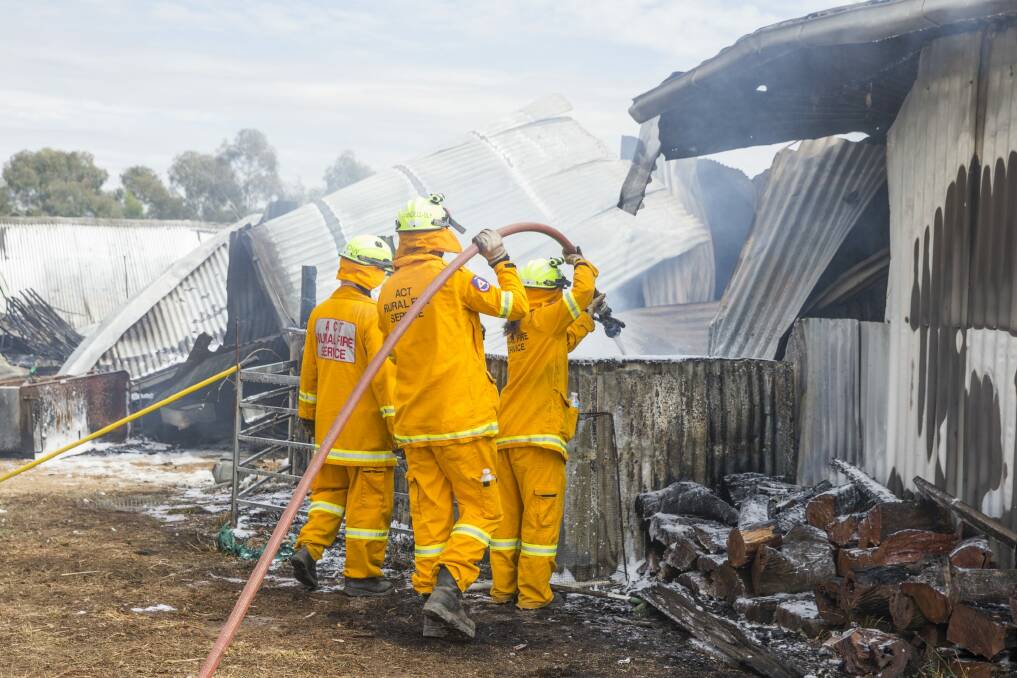 Firefighters mop up after a fire at Gold Creek Station near Hall destroyed the function centre. Photo: Matt Bedford