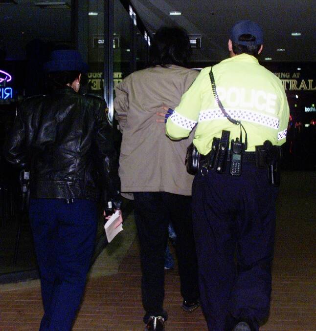 About 50 alleged gangsters, including this unidentified person, were arrested in this raid on a Chinese restaurant in 2002. Mr Guo admitted he was in the restaurant that night but denied any knowledge of the strong Triad presence. Photo: Steve Lunam