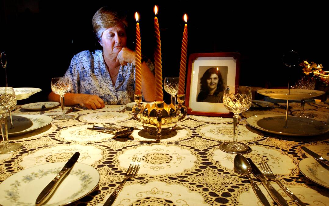 Trish Riggs' mother Carol Saxton at home in Queanbeyan in 2003. Her daughter made the tablecloth and Mrs Saxton always laid it out at Christmas. Mrs Saxton died in 2011, not knowing what happened to her daughter. Photo: Andrew Campbell
