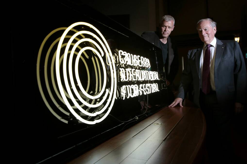 Canberra International Film Festival boardmember Cris Kennedy and general manager Andrew Pike with the neon sign made to promote the festival at the National Film and Sound Archive. Photo: Jeffrey Chan