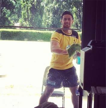 ACT Brumbies flyhalf Christian Lealiifano washes windows at the club's Griffith headquarters.
