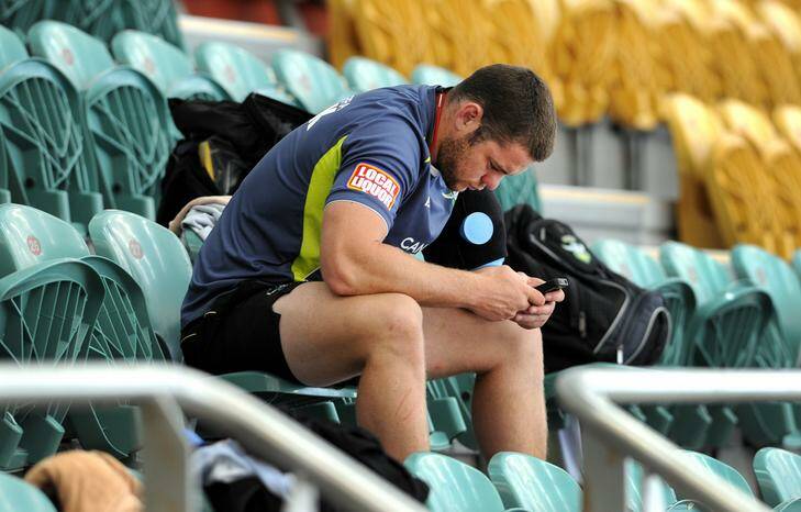 Injured player, Shaun Fensom, sits out the session as his team mates take to the pool. Photo: Graham Tidy