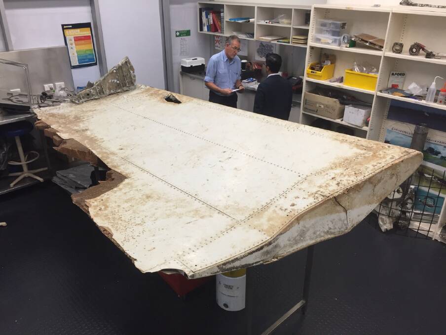 Malaysian and Australian investigators examine the piece of aircraft debris found on Pemba Island off the coast of Tanzania Photo: ATSB