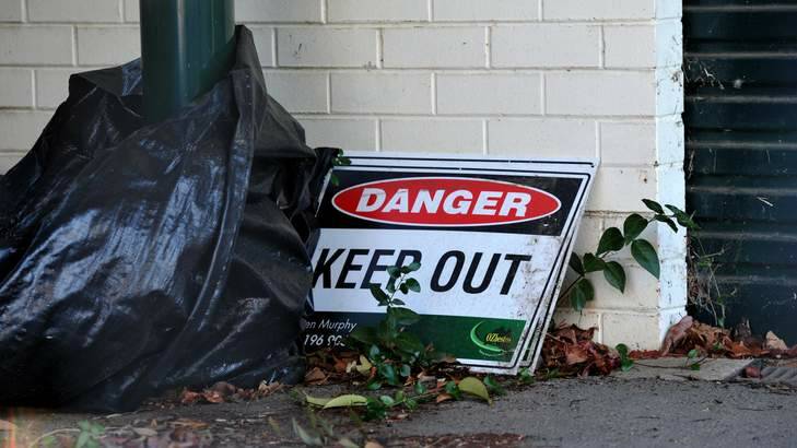 A sign sits outside of the Bradfield Street house that is due to be demolished because of the asbestos it contains. Photo: Graham Tidy
