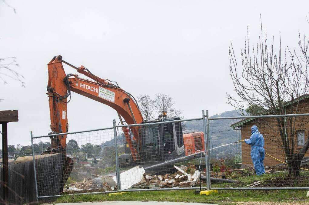 Workers demolish a Mr Fluffy home. Photo: Rohan Thomson