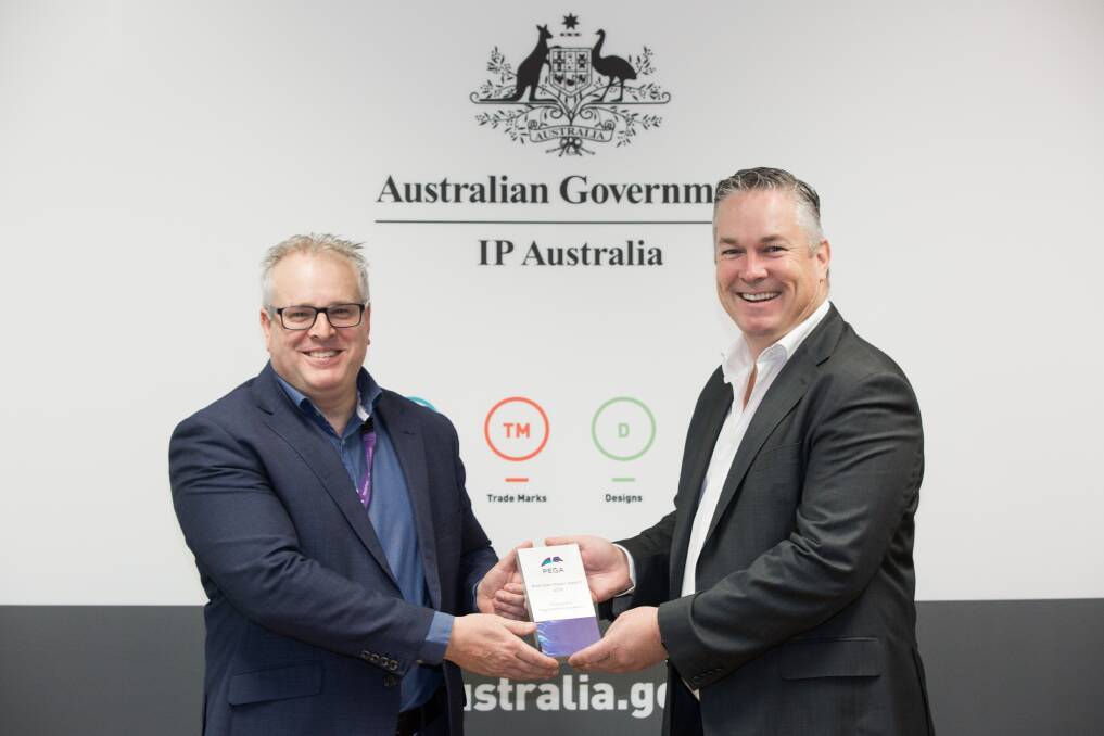 IP Australia general manager Robert Bollard receiving the award from Pegasystems's Luke McCormack.  Photo: Supplied