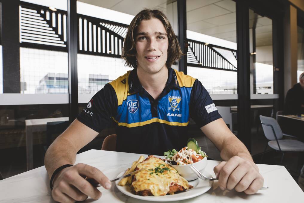 Canberra Demons player Alex Paech with his parma for a farmer at the Eastlakes club in Gungahlin. Photo: Jamila Toderas