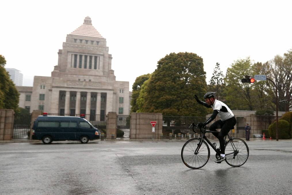 Prime Minister Tony Abbott on an early morning bike ride past the National Diet Building in Tokyo last year. A cycling present from the Japanese prime minister was the most expensive gift Mr Abbott will keep from his time as national leader. Photo: Alex Ellinghausen