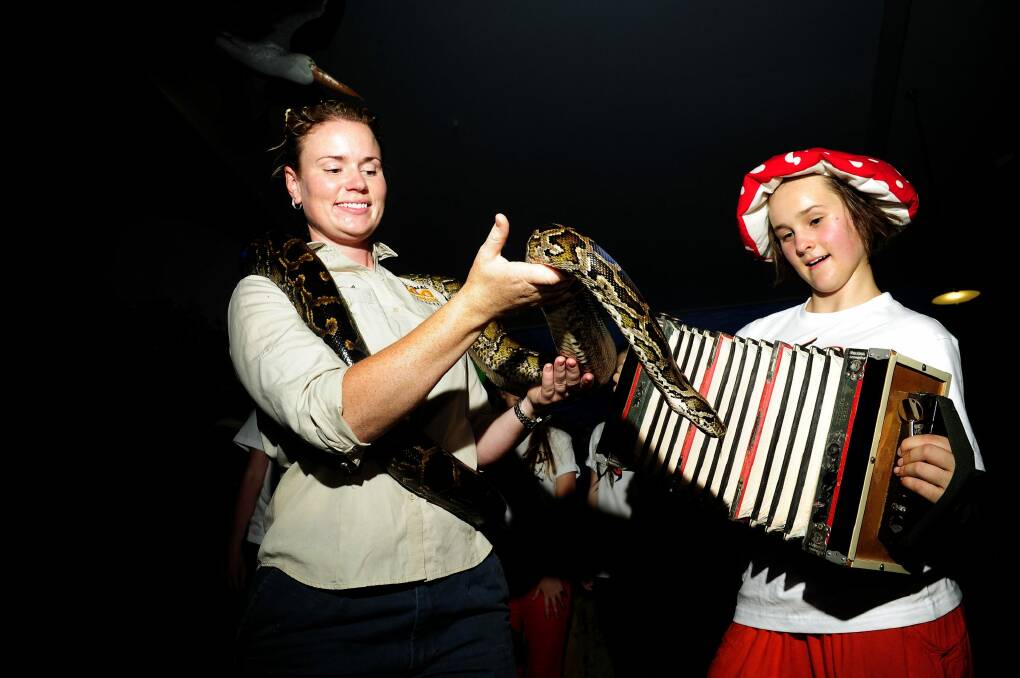 National Zoo and Aquarium senior wildlife keeper Renee Osterloh with Burnie the Burmese Python and Tilda Blackbourn-Rooney from Wild Voices Music Theatre who will perform at the zoo during Enlighten. Photo: Melissa Adams