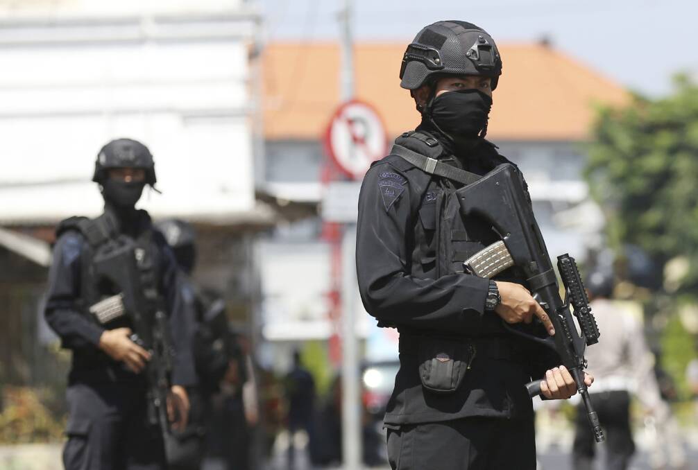 Officers stand guard outside the local police headquarters following an attack in Surabaya, East Java, Indonesia, on Monday. Photo: AP