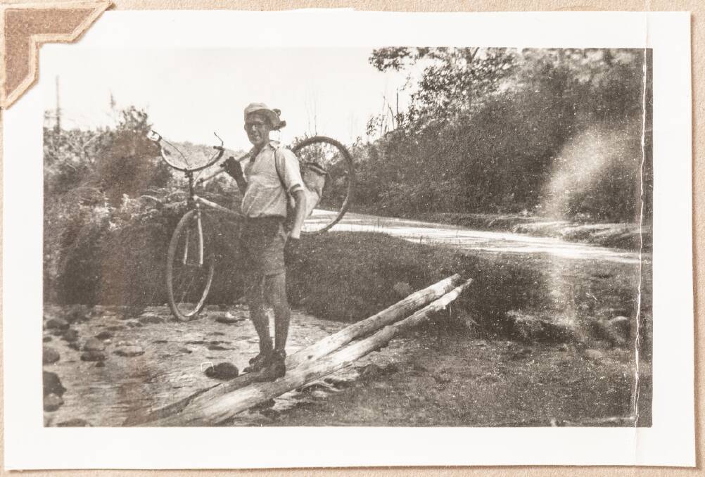 Alan McArthur carries his bike across a creek during the ride. Photo: Chris Woods