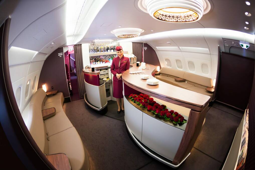 A Qatar Airways cabin crew member at the Airbus A380 First Class bar and  lounge. Photo: SHUTTERSTOCK