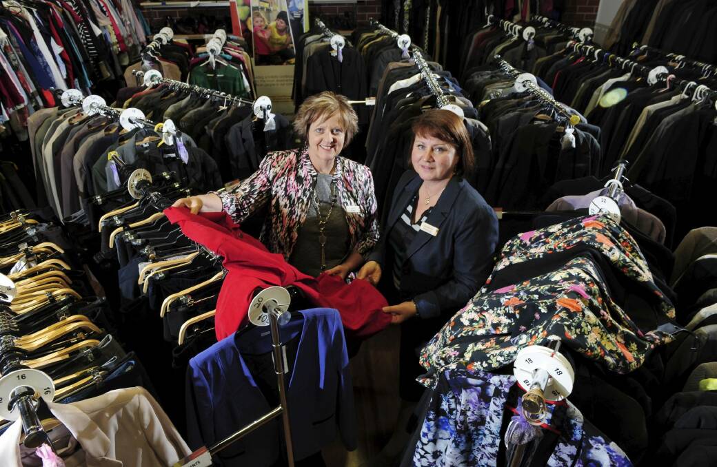Kim Bool, director of social programs with not-for-profit organisation Communities@ at Work, left, with chief executive Lynne Harwood, surrounded by clothing for sale.  Photo: Graham Tidy