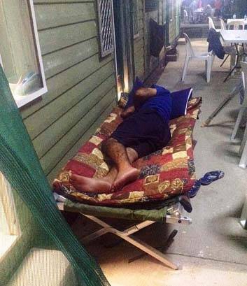 An asylum seeker sleeps outside to escape stifling heat.