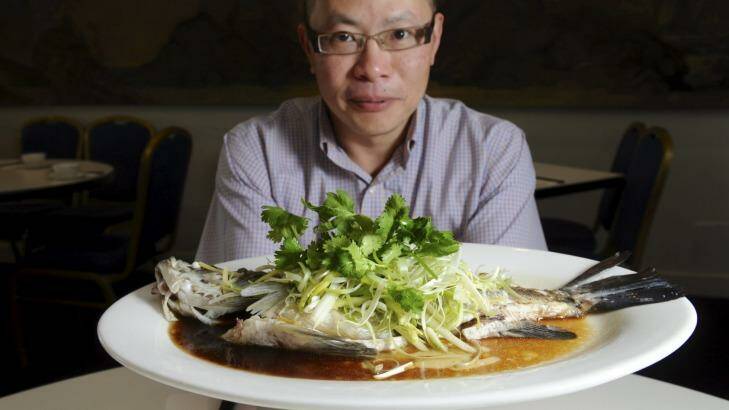 Tempting dish: Jimmy's Place manager, Raymond Wong, with a cooked barramundi.  Photo: Graham Tidy
