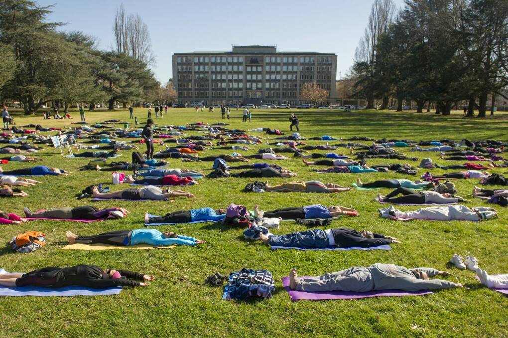 Canberrans participate in an outdoor yoga class to mark the official International Day of Yoga. Photo: Jay Cronan