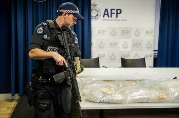 An armed police officer stands guard over one of the ACT's largest drug seizure of methamphetamine. Photo: Jay Cronan