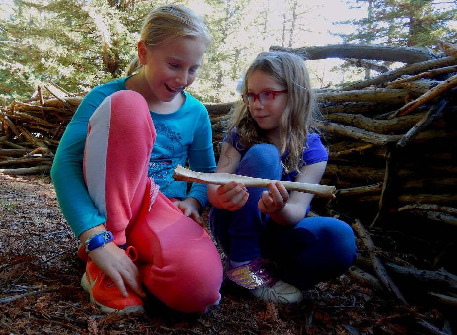 Sarah and Emily examine a kangaroo bone found in the Pialligo Redwood Forest fort. Photo: Tim the Yowie Man