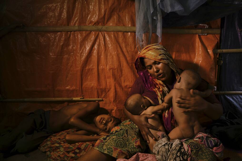 Fatima Begum comforts her twins Asia and Rubina as her son, Sadeka, who is sick, lays at her side. Photo: Kate Geraghty