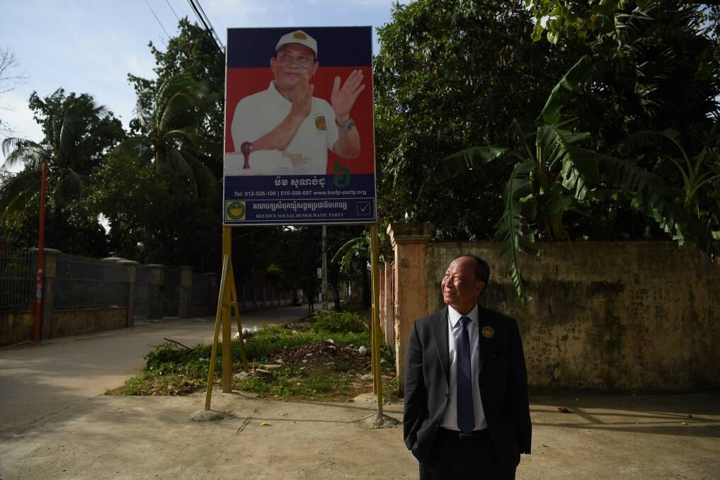Mam Sonando stands in front of his campaign banner at the Beehive Social Democratic Party headquarters outside Phnom Penh.  Photo: Kate Geraghty