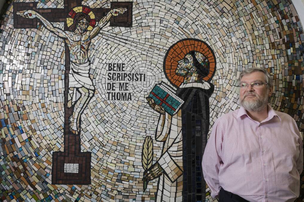 Australian Catholic University campus dean, Associate Professor Patrick McArdle, with the mural in the listed building. Photo: Sitthixay Ditthavong