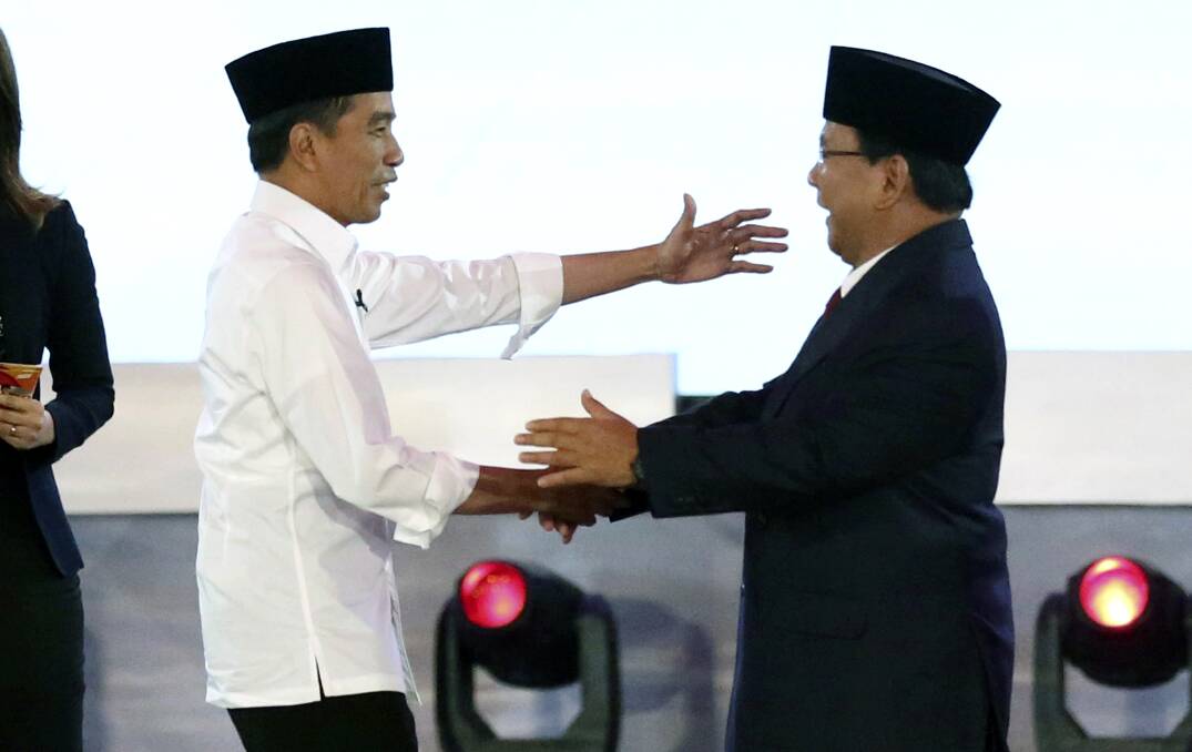 Indonesian President Joko Widodo, left, and his contender Prabowo Subianto shake hands after a televised debate last month. Photo: AP
