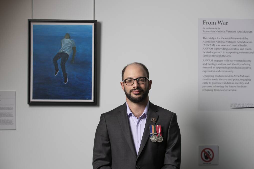 Artist Saif Shamkhi beside his painting <i>Pusser Post Resolute</i> hanging at Parliament House. Photo: Sitthixay Ditthavong