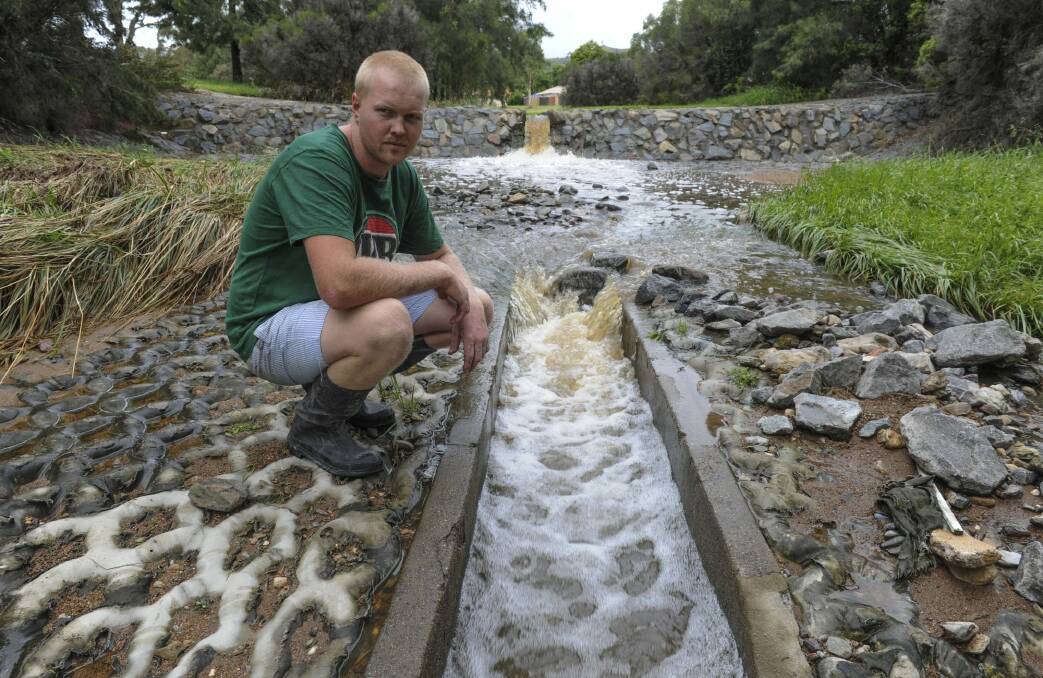 Gordon resident Caleb Watt is a near neighbour of the family of the two-year-old swept down this flooded stormwater drain on Saturday evening.  Photo: Graham Tidy