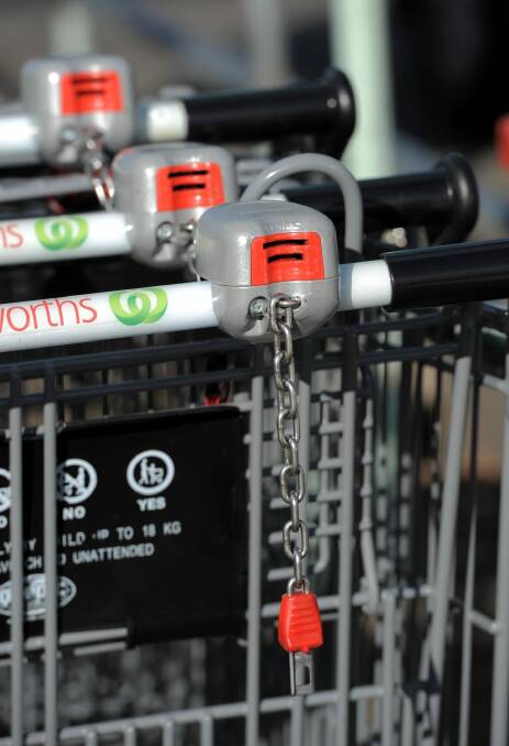 Coin lock systems and electronic wheel locks are being installed to reduce shopping trolleys being dumped and abandoned across the ACT. Photo: Graham Tidy