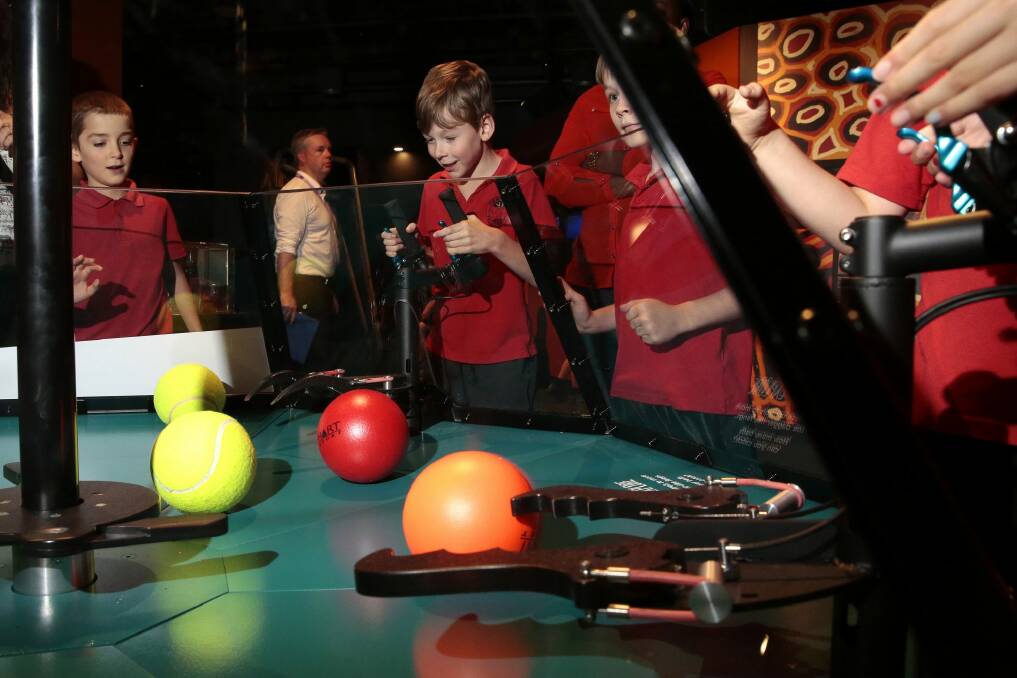 Dante Wilkes and Tynan Pratt try out an interactive exhibit at the Spiders display. Photo: Jeffrey Chan