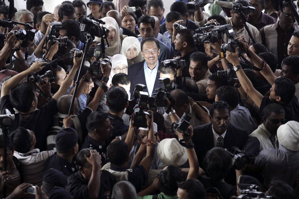 Then Malaysian opposition leader Anwar Ibrahim, centre, is surrounded as he arrives at court in 2008. Photo: AP/File