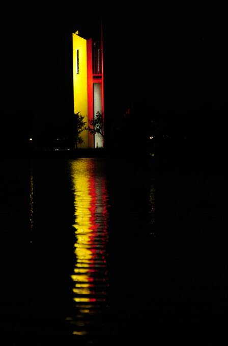 The National Carillon reflecting Belgium's national colours of red, black and yellow on Lake Burley Griffin. Photo: Melissa Adams