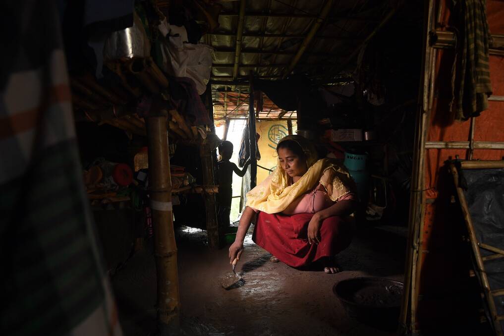 Rohingya refugee Asmida Khatun, 30, smooths out cement on the floor of her family’s shelter. Photo: Kate Geraghty