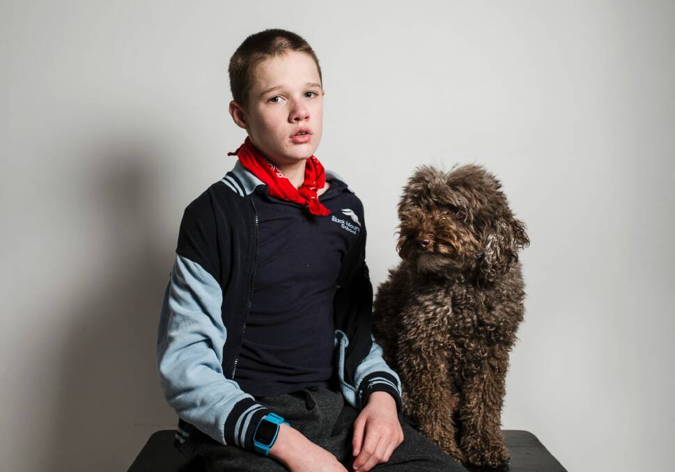Logan, pictured with his therapy dog Simi, has autism and requires one-on-one care at Marymead's respite service. Photo: Jamila Toderas