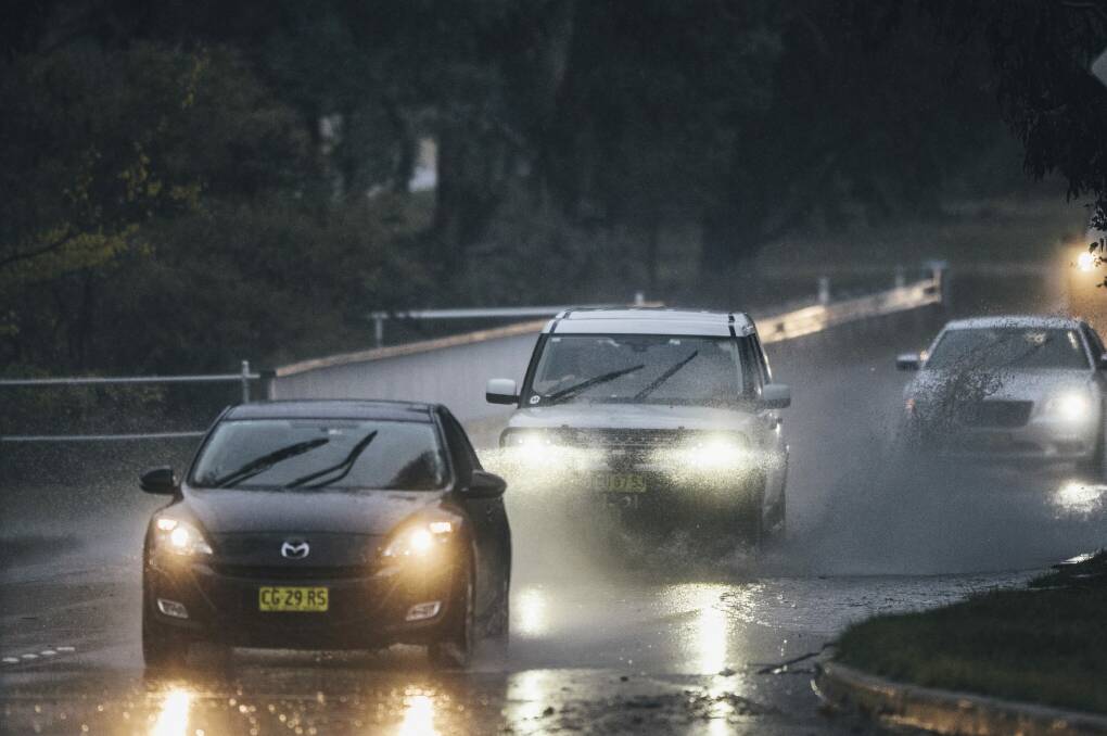 A car passes through water on Parkes Way.  Photo: Rohan Thomson
