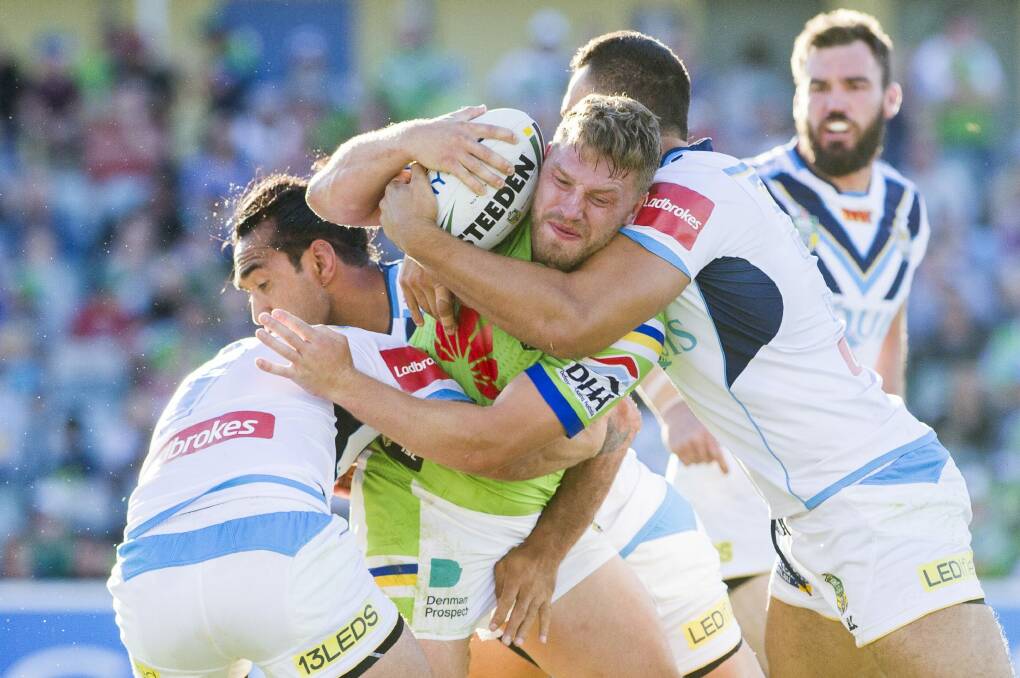 Tough going: Five-eighth Elliot Whitehead hits the Titans defence. Photo: Jay Cronan