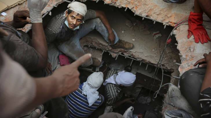 Rescuers descend into holes cut in the concrete as they search for survivors. Photo: AP