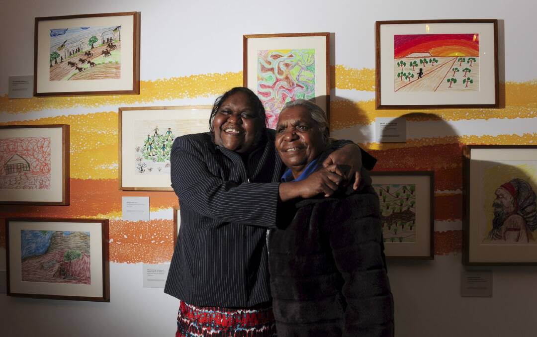 Mother and daughter artists from
Yuendumu, Tess Napaljarri Ross, right and Elisabeth Naparrurla Ross, in front of some of their work at the opening of their exhibition "Warlpiri Drawings". Photo: Graham Tidy