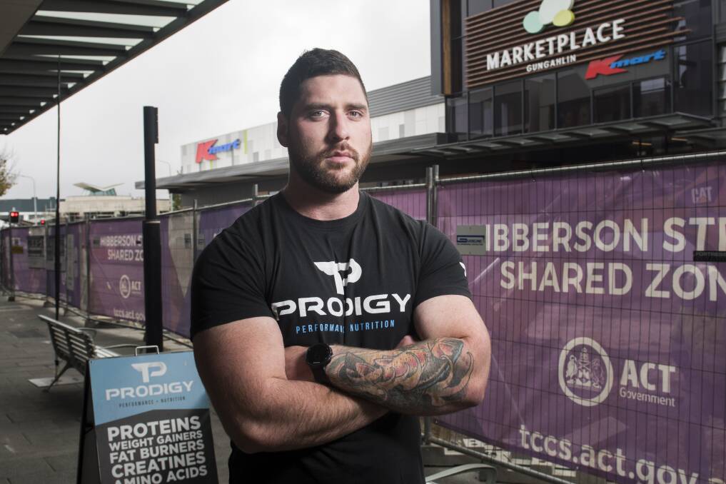 Cam McAlister, owner of Prodigy Supplements says the Gungahlin town centre has become a ghost town because of the light rail construction noise and hoarding. He recorded noise of 93 decibels with all of his shop doors closed.  Photo: Elesa Kurtz