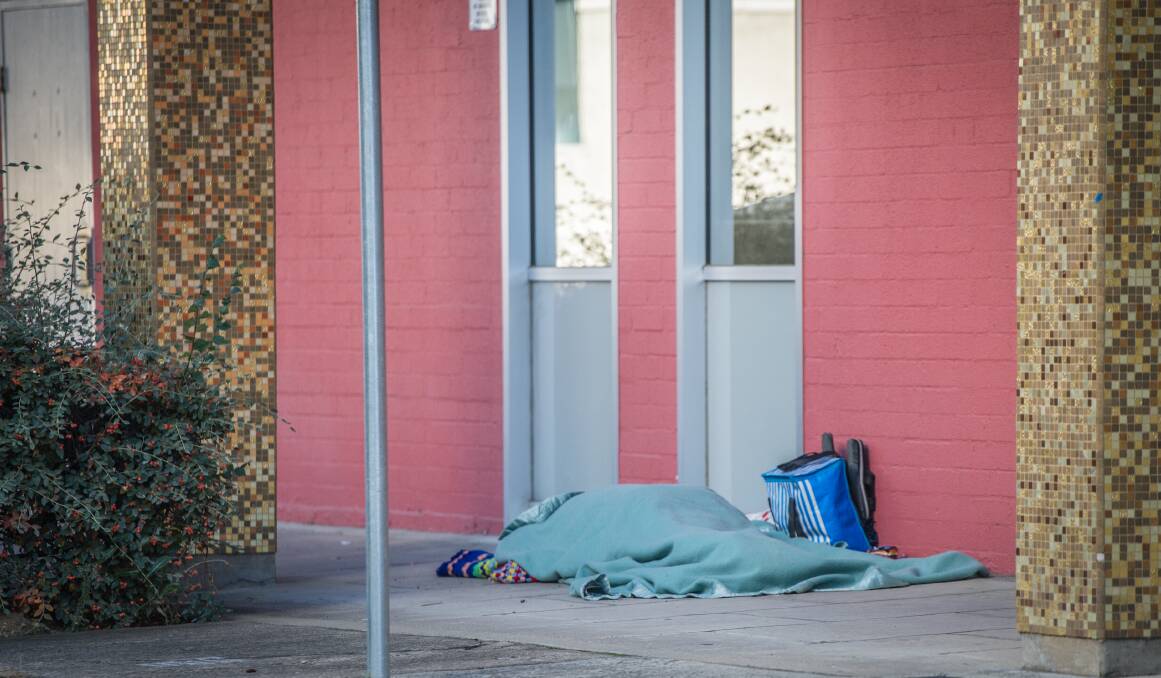 A homeless person sleeps rough outside the ACT Legislative Assembly on Monday. Photo: Karleen Minney