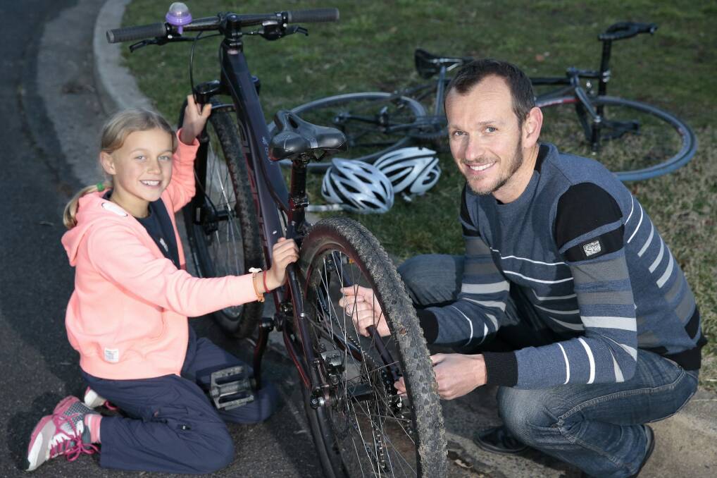Isobel Jones, 9, of Downer gets ready to go for a bike ride with her father Stuart Jones.  Photo: Jeffrey Chan