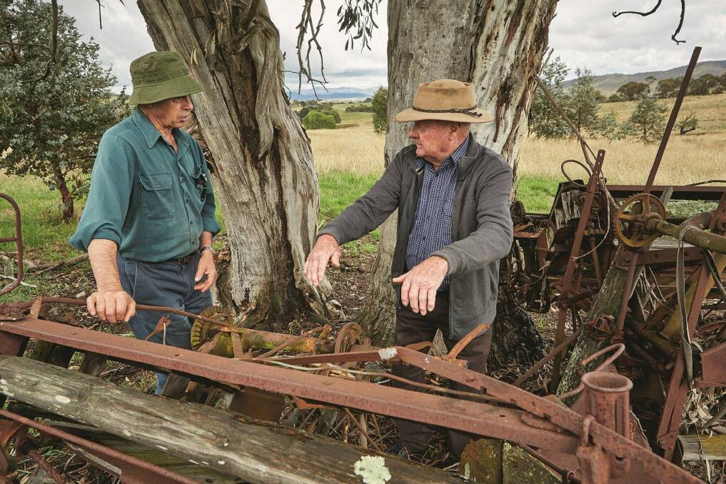 Author Richard Begbie (left) and Max Oldfield interpret the fiendish complexities of an abandoned reaper and binder this year. Photo: Peter Campbell