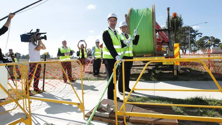 Communications Minister Stephen Conroy and Labor MP Andrew Leigh assist in laying the fibre optic cable for a photo opportunity, in the Canberra suburb of Gungahlin. Photo: Alex Ellinghausen