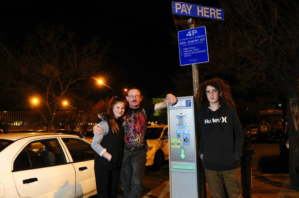 Centre, Alex Humphreys of Stirling with his children, from left, Ellis aged 13 and Caleb aged 15 react to the change to parking fees in city. Photo: Melissa Adams