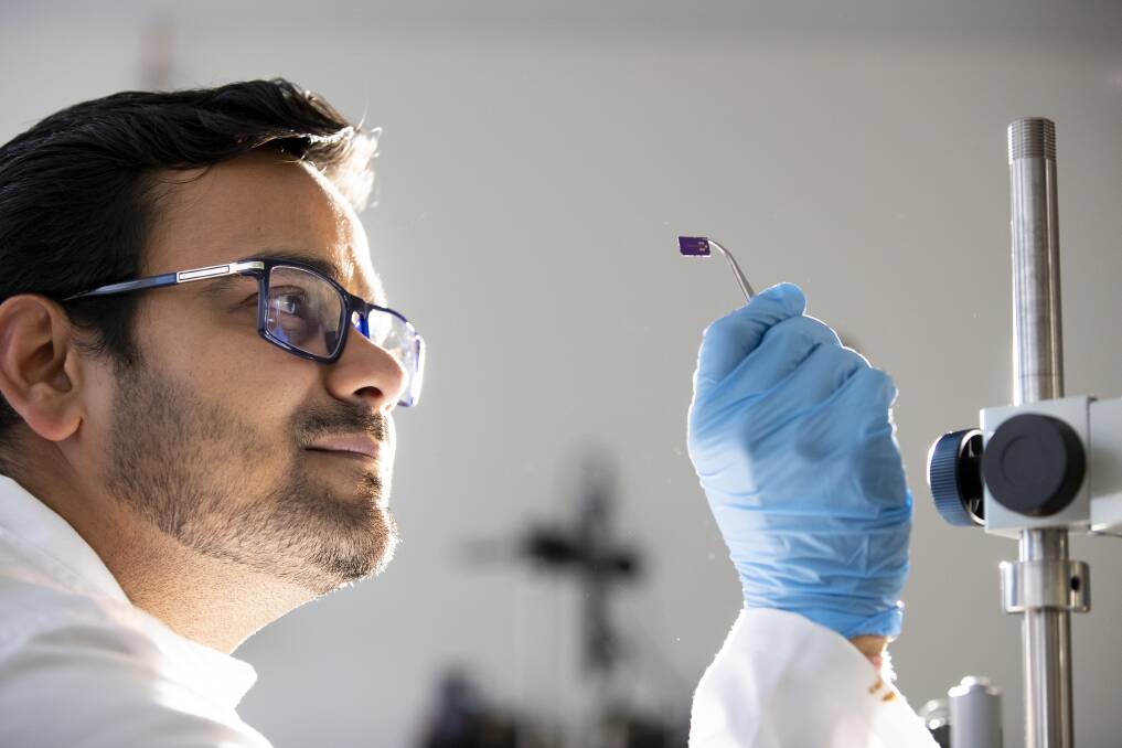 ANU PhD candidate Ankur Sharma examines a new biodegradeable, bendable organic semi-conductor, which aims to lead the way to bendable phones.  Photo: Sitthixay Ditthavong