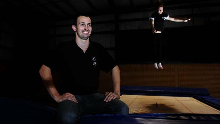 Jack Ratz, coach of the Canberra Trampoline and Sports Club, with Djakirri Crafter, 14, of Yass practising in the background at Daramalan College, Dickson. Photo: Melissa Adams